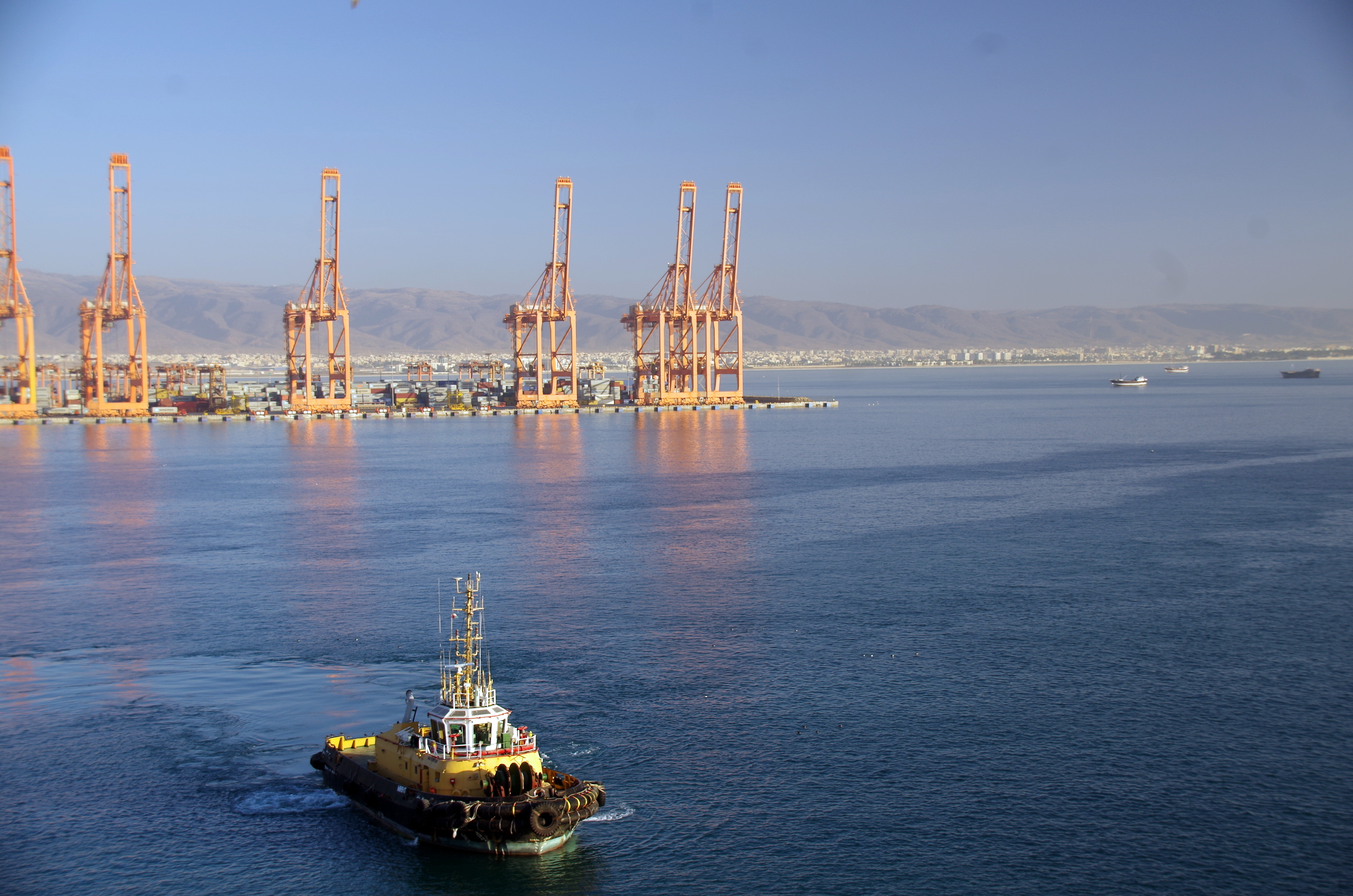 Container cranes, logistics facilities and a tugboat at the Port of Salalah, Oman — international trade reference, not an MCI facility
